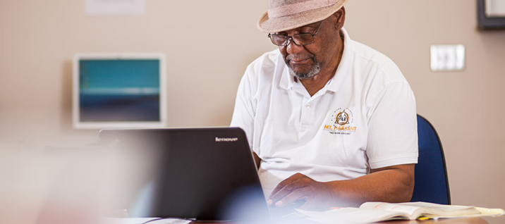An older male student works on his laptop