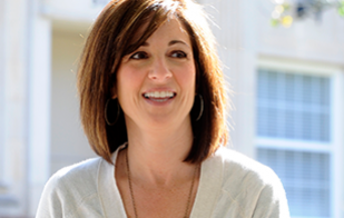 An image of a female student smiling in the sunshine