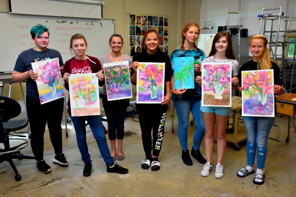 Students holding their created water color paintings