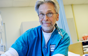 Male nursing student smiling at camera in hospital