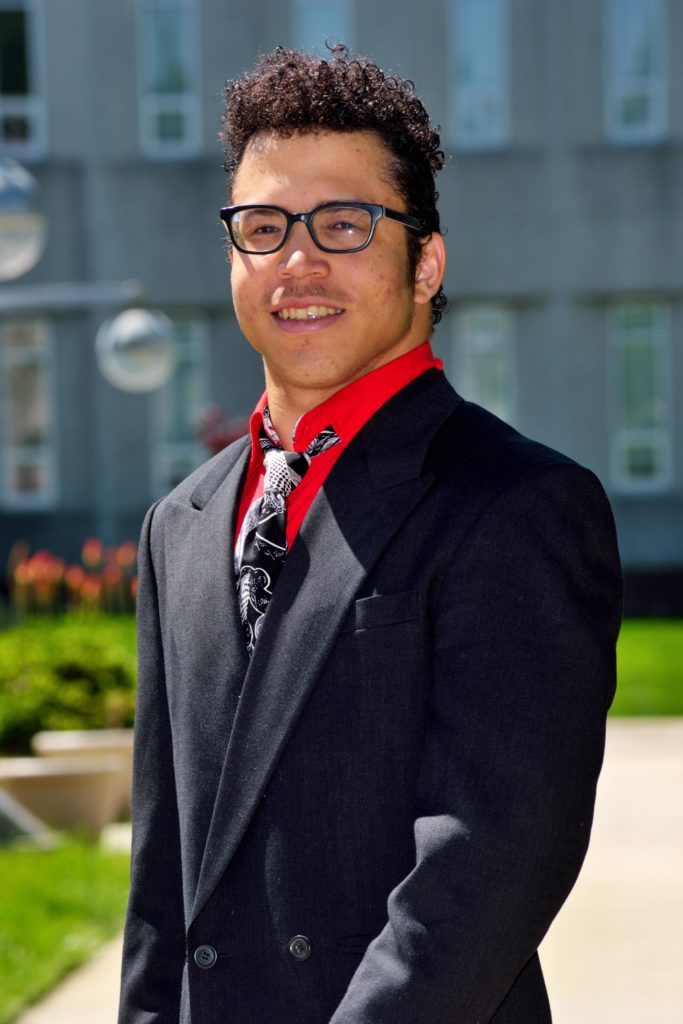 Student posing in front of campus building