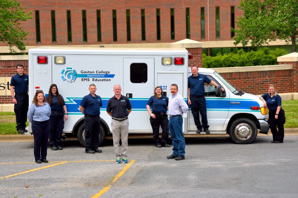 Group of people standing in front of an ambulance