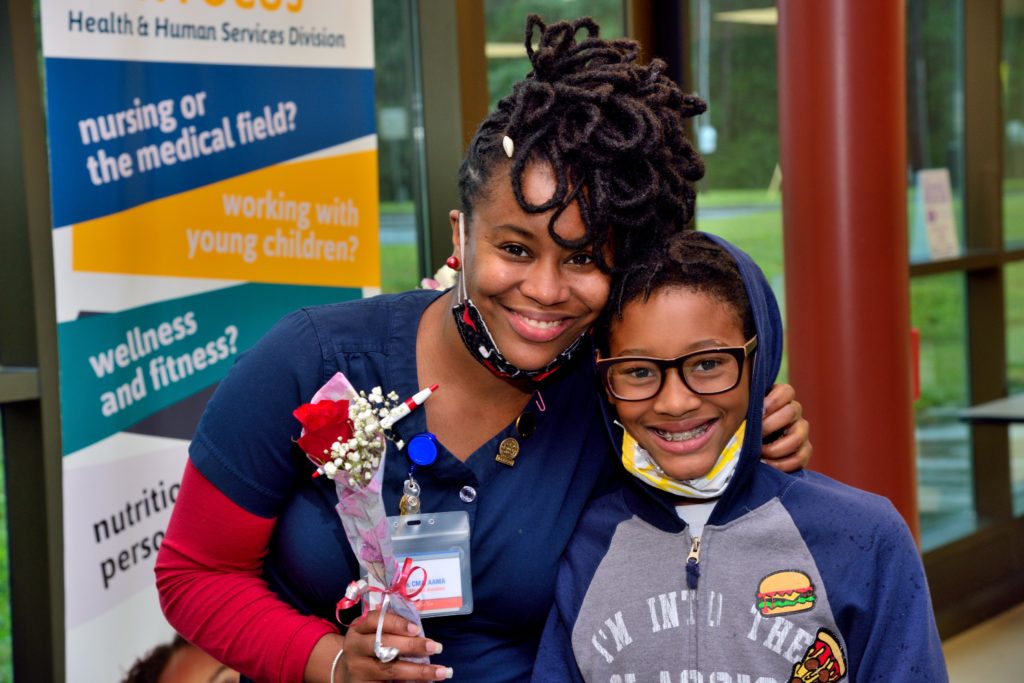 woman holding flowers posing with her son