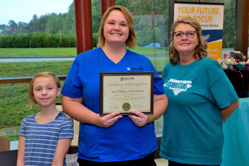 Gaston College Graduate Dara Williams posing with daughter and an instructor