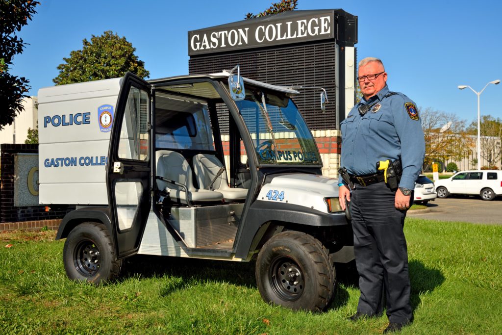 police officer standing next to utility vehicle