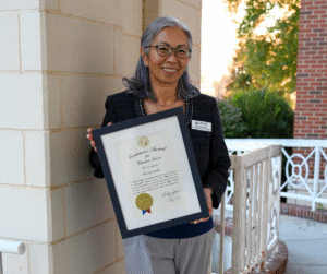 Gaston Instructor Hisayo Tokura-Gallo smiling with Governor's Award Certificate.